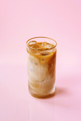 cold coffee ice latte in a glass isolated on a pink background