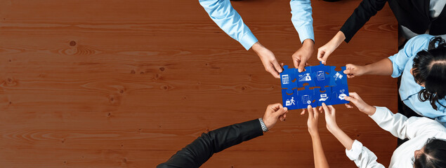 A diverse group of professionals collaborates over a blue board in a modern office setting. The scene captures teamwork, strategy development, and creative problem-solving. Amity