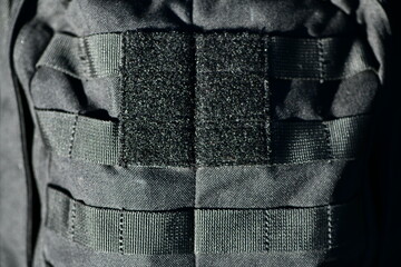 Close-up image of black velcro strips on a black tactical military backpack