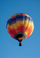 Naklejka premium Colorful hot air balloon soaring against a clear blue sky