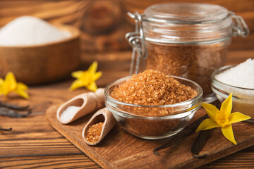Aromatic vanilla sugar. Vanilla pods. Vanilla sticks, brown and white sugar in a bowl on a textured background. Vanilla flowers, spices and herbs for desserts and baking. Space for text. Copy space