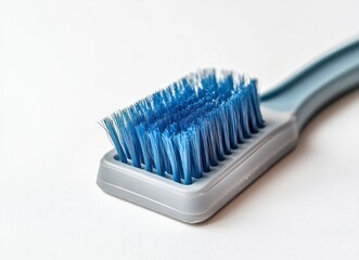 Close-up of Blue Bristled Brush with Gray Handle on White Surface