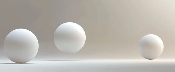 Three white spheres resting on a plain white surface