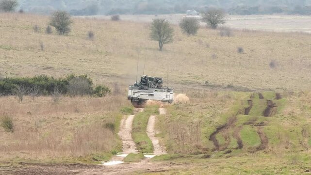 a British army General Dynamics Ajax Ares tank being tested across muddy ground
