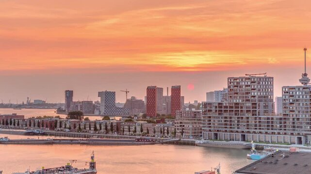 Aerial timelapse panorama of Katendrecht peninsula and Maashaven harbour at sunset in Rotterdam, The Netherlands. Features city skyline, modern skyscrapers and traditional Dutch waterfront houses