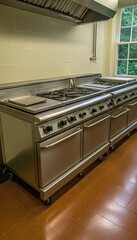 Two large, stainless steel commercial stoves with ovens sit in a kitchen, ready for use.