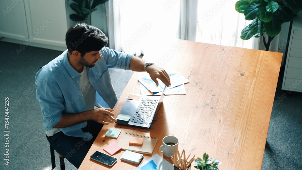 Poster skilled businessman writing idea on colorful sticky notes while looking at data analysis. caucasian 