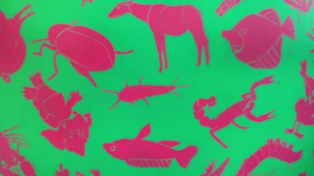 A green background with a pattern of insects and animals. A horse is in the middle of the pattern