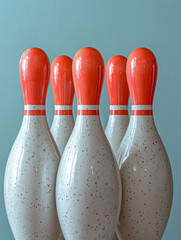 Five bowling pins with orange tops against a blue background.