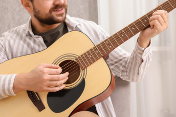 Obraz premium Relaxing hobby. Smiling man playing guitar at home, closeup