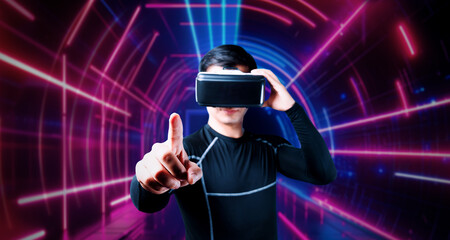 Professional male gamer with VR glasses pointing and playing game with glowing neon light. Excited player enjoy connecting in metaverse while using augmented reality technology innovation. Ingenuity.