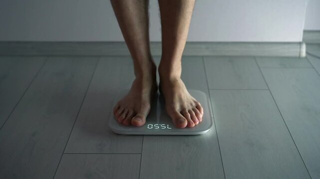 A person is weighed on scales.
Scales for measuring body weight.
A person steps on the scales