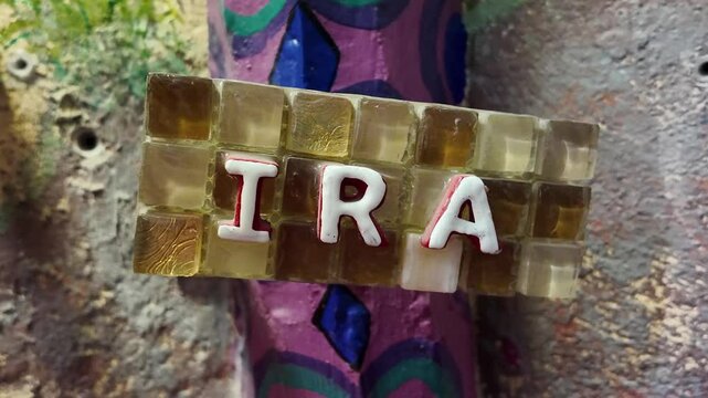 A sign with the name IRA on it. The letters are in white and the background is purple