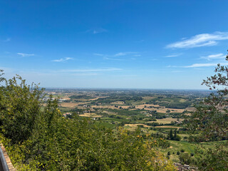 Obraz premium Panoramic view overlooking vast cultivated fields and lush green vegetation in italy