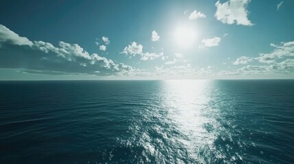Obraz premium A vast, open ocean under a bright sun with waves reflecting the sunlight.