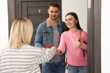 Woman welcoming new neighbors to her apartment