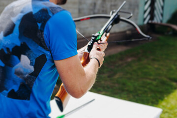 Crossbow shooting and archery at the shooting range, women and men practicing with arbalest at...