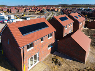 The roof of a new build houses on a construction site with integrated solar panels