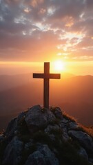 Wooden cross is on top of a rock in front of a beautiful sunset. Concept of peace and serenity, as the cross stands as a symbol of faith
