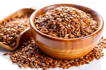 A wooden bowl filled with brown flax seeds sits on a white surface, with some seeds scattered around it.