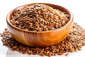 A wooden bowl filled with brown flax seeds sits on a white surface, with some seeds scattered around it.