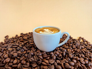An Artisan Coffee Cup beautifully placed on a Bed of rich Coffee Beans, creating an inviting scene