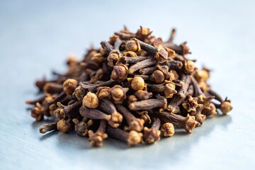 Obraz premium A close-up shot of dried cloves, the aromatic flower buds of the clove tree, piled together on a white background.