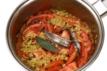 pan with chopped tomatoes, chopped onions and sardines to be sautéed to make sauce close-up
