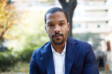 Naklejka premium African American young man wearing blue suit posing outdoor and looking at the camera.