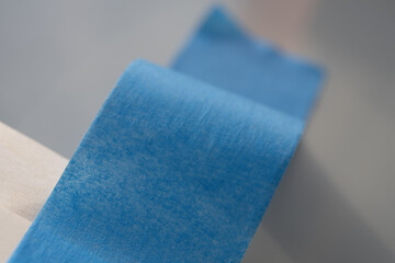 Close-up of blue painter's tape roll. A macro shot of blue painter's tape, showing its texture and adhesive side. Ideal for painting, masking, and surface protection.  

