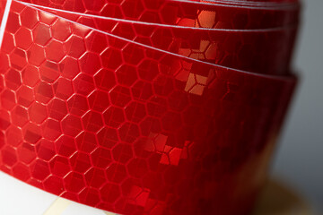 Close-up of red reflective safety tape roll  
A detailed close-up of a roll of red reflective...