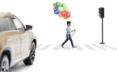 Boy carrying a bunch of balloons and walking at a pedestrian crossing