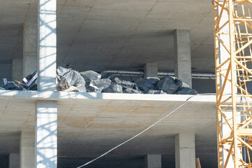 Construction site with debris above concrete walls reflects industry progress during a sunny...