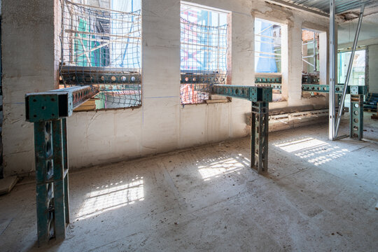 Construction site with sunlight through windows and metal beams