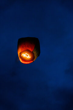 Floating Chinese lantern with wishes in the night sky