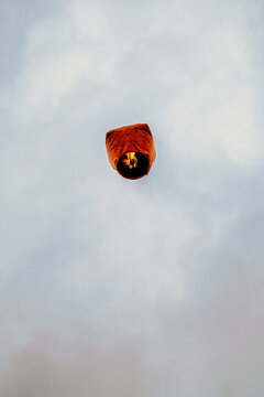 Low angle view of floating Chinese lantern against sky