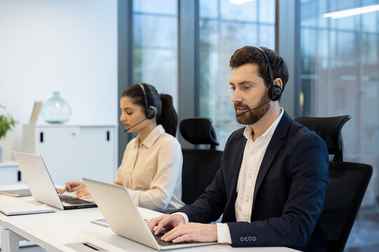 Attentive call center agents are diligently working on laptops, providing customer service support.
