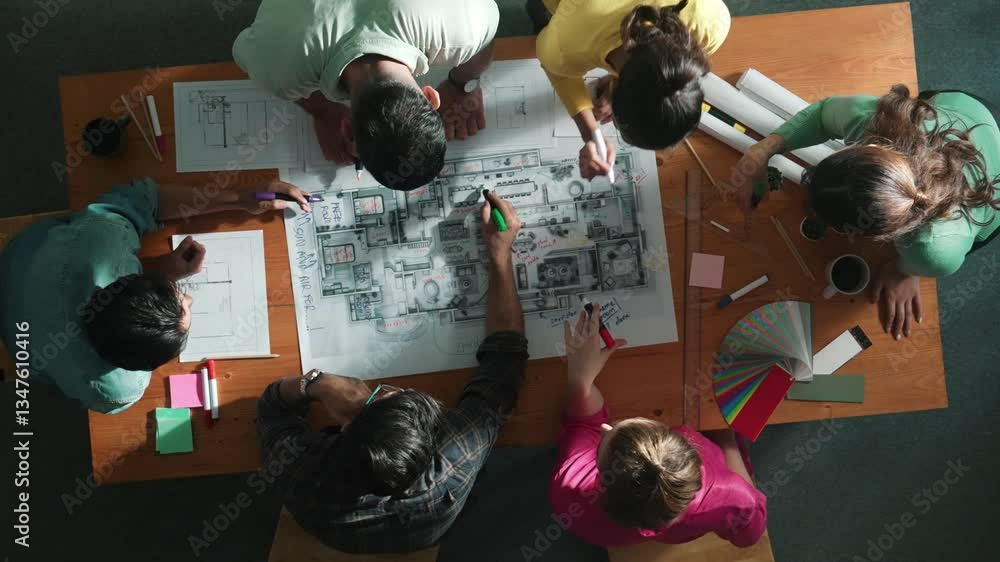 Poster top down view of civil engineer team writing at blueprint at meeting table with color palettes. grou