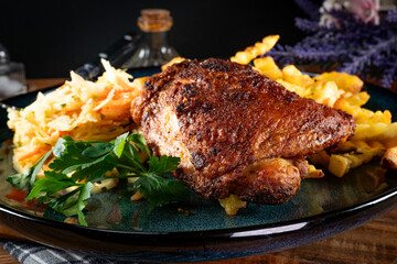 Crispy roasted chicken piece with french fries and salad.