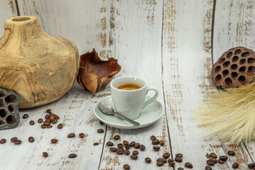 Espresso coffee with spoon and coffee beans on rustic wooden table
