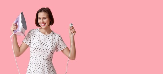 Young woman with iron on pink background with space for text