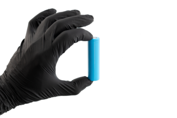 Hand in glove holds light blue rechargeable lithium-ion battery type 18650 for electrical appliances and devices, on isolated background, with space for text.
