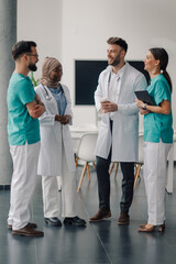 Medical team discussing patient cases in hospital corridor