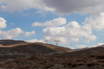 Desert Currents: Rugged hills and arid terrain host resilient power towers and transmission lines, marking the junction of nature and modern infrastructure.
