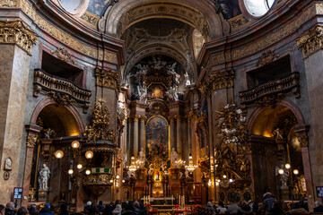 Tourists admiring the opulent interior of St. Peter's Church in Vienna