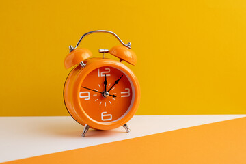 Orange alarm clock on color background. Trendy minimalist style. Time, business and technology...