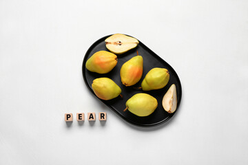 Word PEAR and plate with fresh fruits on white background