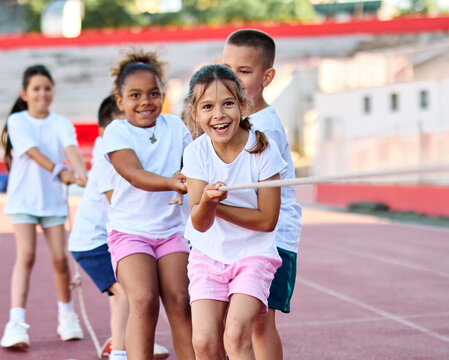 child sport exercise athlete rope competition strength challenge teamwork effort pulling pull tug rivalry struggle war conflict power contest team fun