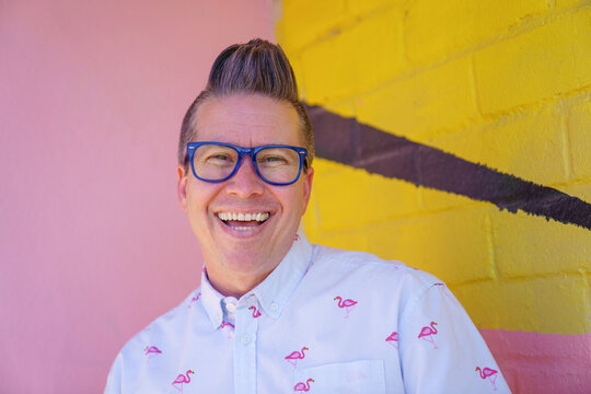 Man happy and smiling, wearing glasses and flamingo shirt and cool hair