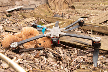 A downed Russian FPV drone lies in the ruins of a destroyed abandoned house next to a child's brown...